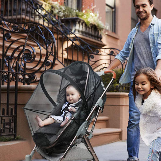 Père-marche-avec-fillette-et-bébé-dans-moustiquaire-poussette-universelle
