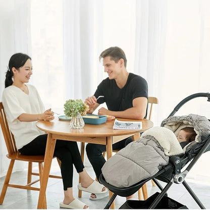 Parents-assis-à-table-à-côté-de-bébé-qui-est-dans-chancelière-poussette-imperméable