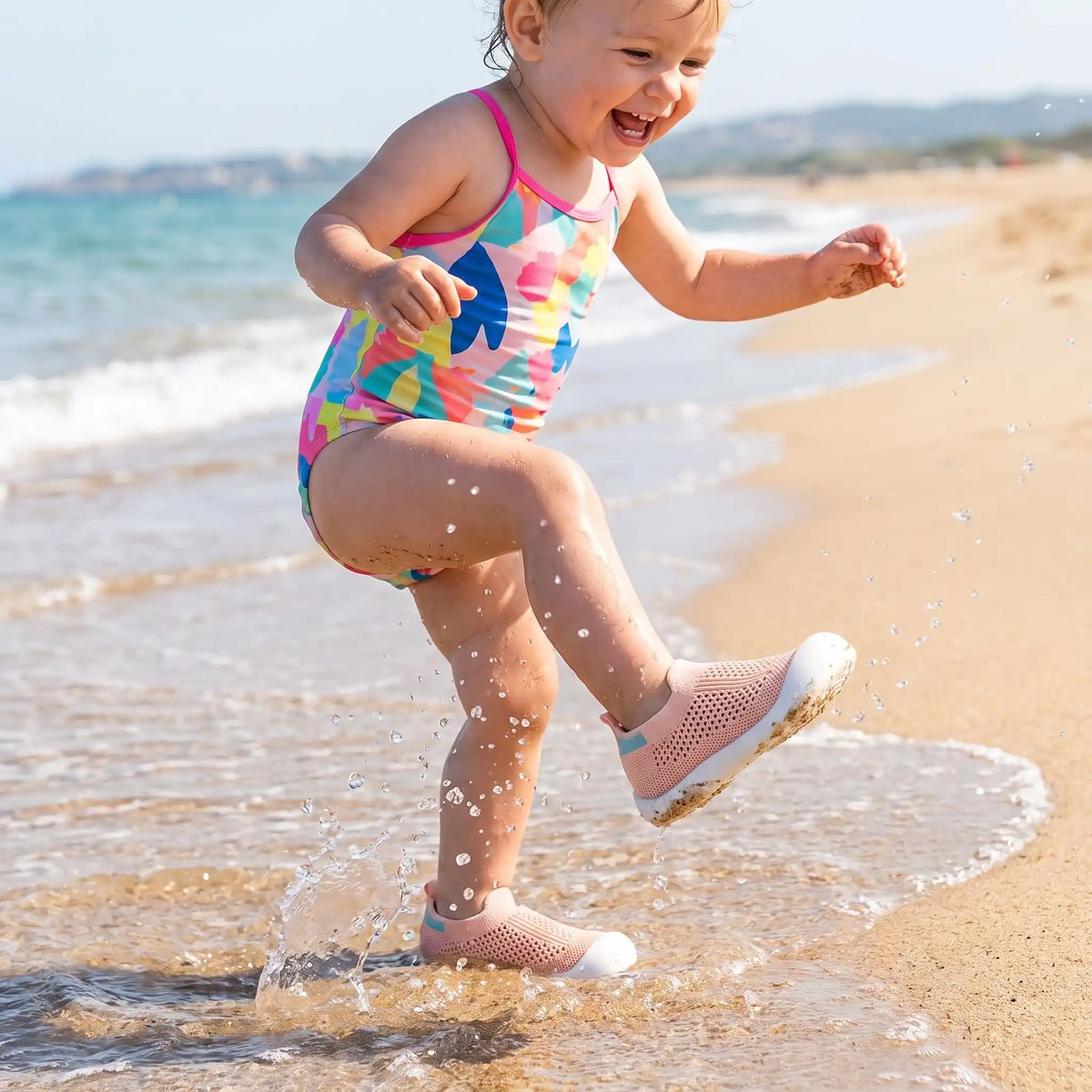Fillette joue dans l'eau avec chaussure bebe mesh respirant rose