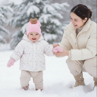Mère et fillette dans neige avec bonnet bebe ourson douillet