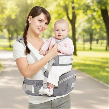 Mère dans parc avec porte-bébé hanche freedom