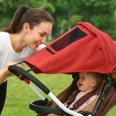Mère-regarde-enfant-sous-pare-soleil-pour-poussette-imperméable