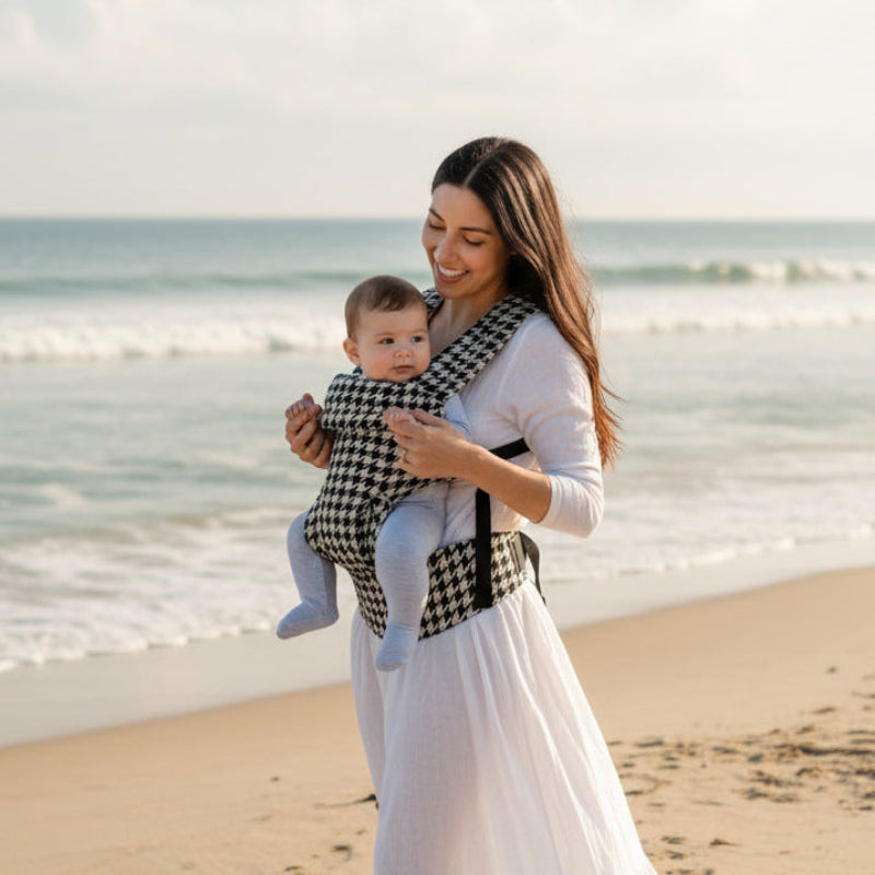 Mère sur plage avec porte bébé ergonomique sécuriflex