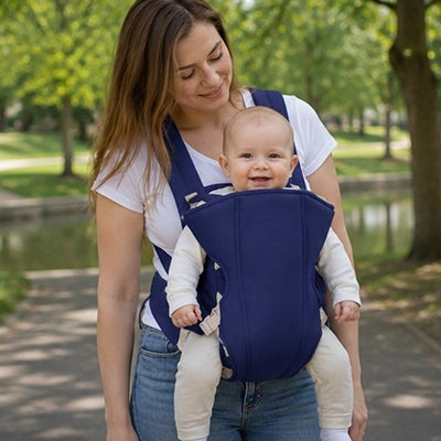 Mère au parc avec porte bébé douillet bleu foncé