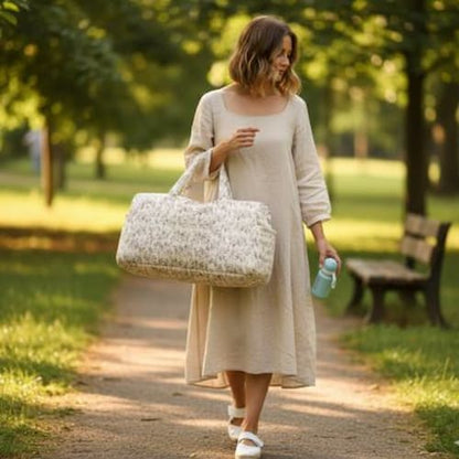 Promenade de maman dans parc avec sac a langer matelassé  fleuri sur bras