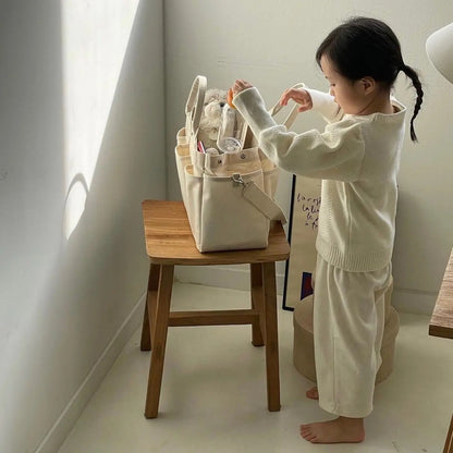 Fillette-joue-avec-sac-à-langer-printanier-couleur-naturelle